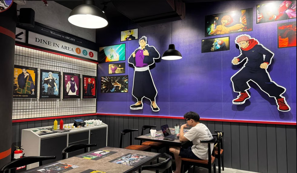 Interior of the Jujutsu Kaisen-themed Arcafe in Jakarta, featuring character murals and standees